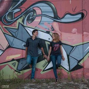 pareja de novios en una pared de graffitis